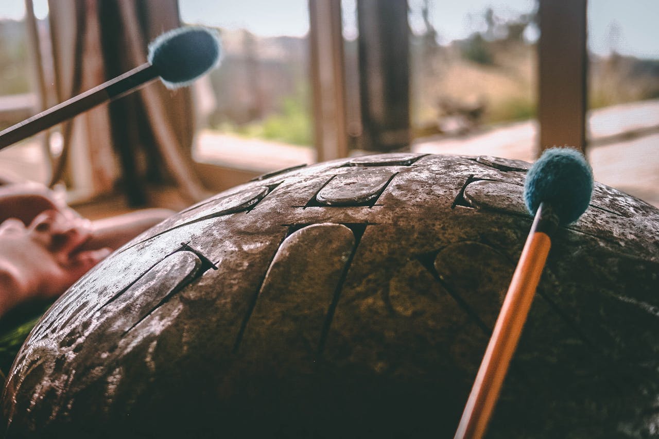 Detailed view of a handpan and mallets, showcasing the texture and serenity of the musical instrument.